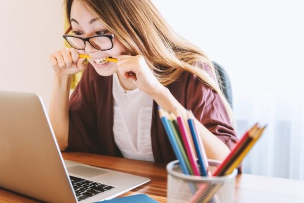 ストレスでペンを噛む女性