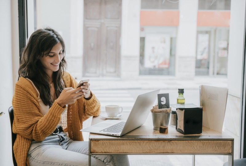 外出先でWiFiを利用し通信する女性