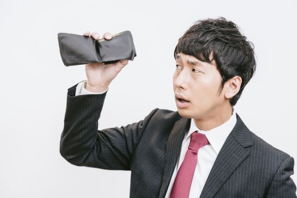 財布を逆さまにする男性