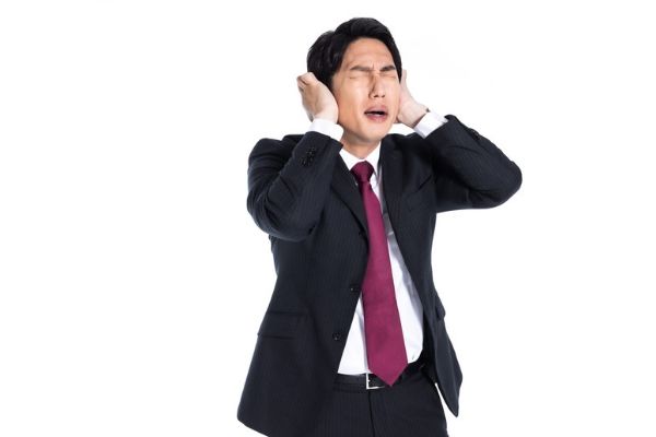 耳をふさぐ男性